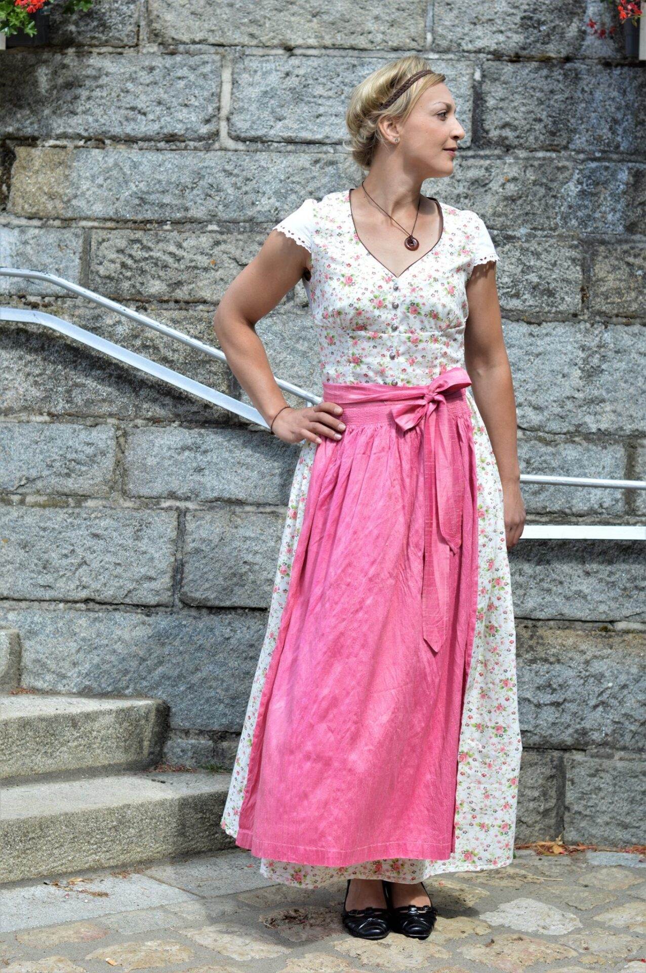 dirndlkleid sissi gr. 32 50 Frau im Dirndl vor Steinmauer