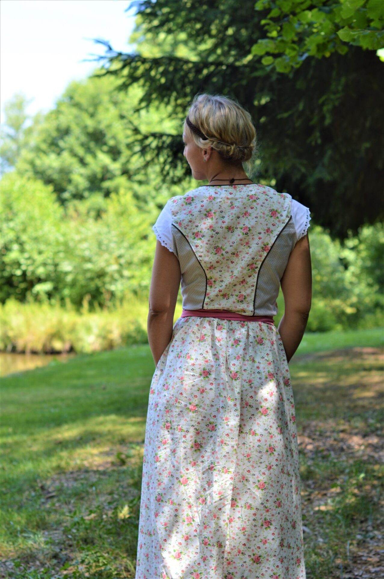 dirndlkleid sissi gr. 32 50 Frau im Blumenmusterkleid im Park