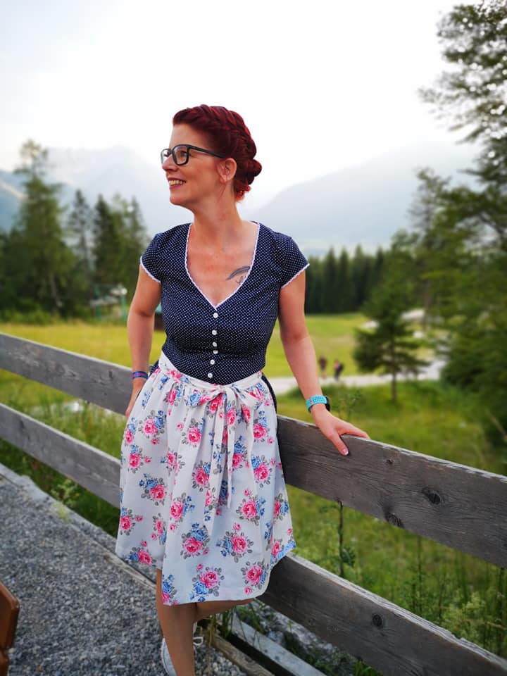 dirndlkleid sissi gr. 32 50 Frau lächelt in ländlicher Umgebung.