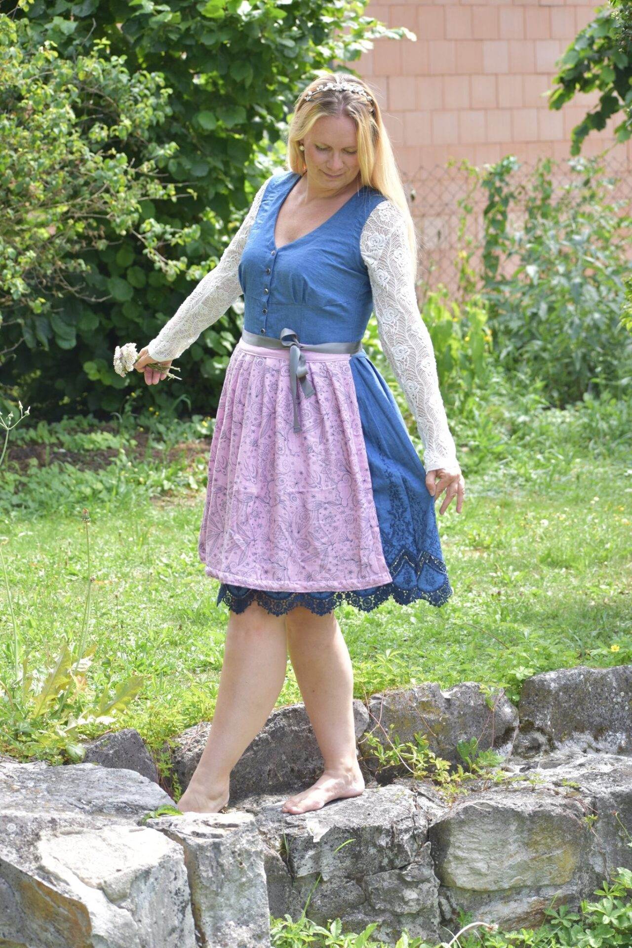 dirndlkleid sissi gr. 32 50 Frau in Dirndl auf Steinen im Garten