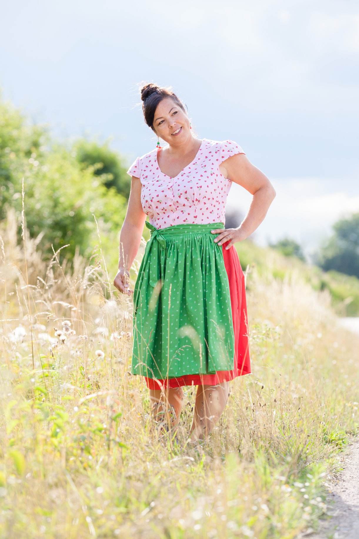dirndlkleid sissi gr. 32 50 Frau im Dirndl auf Wiese bei Sonnenschein