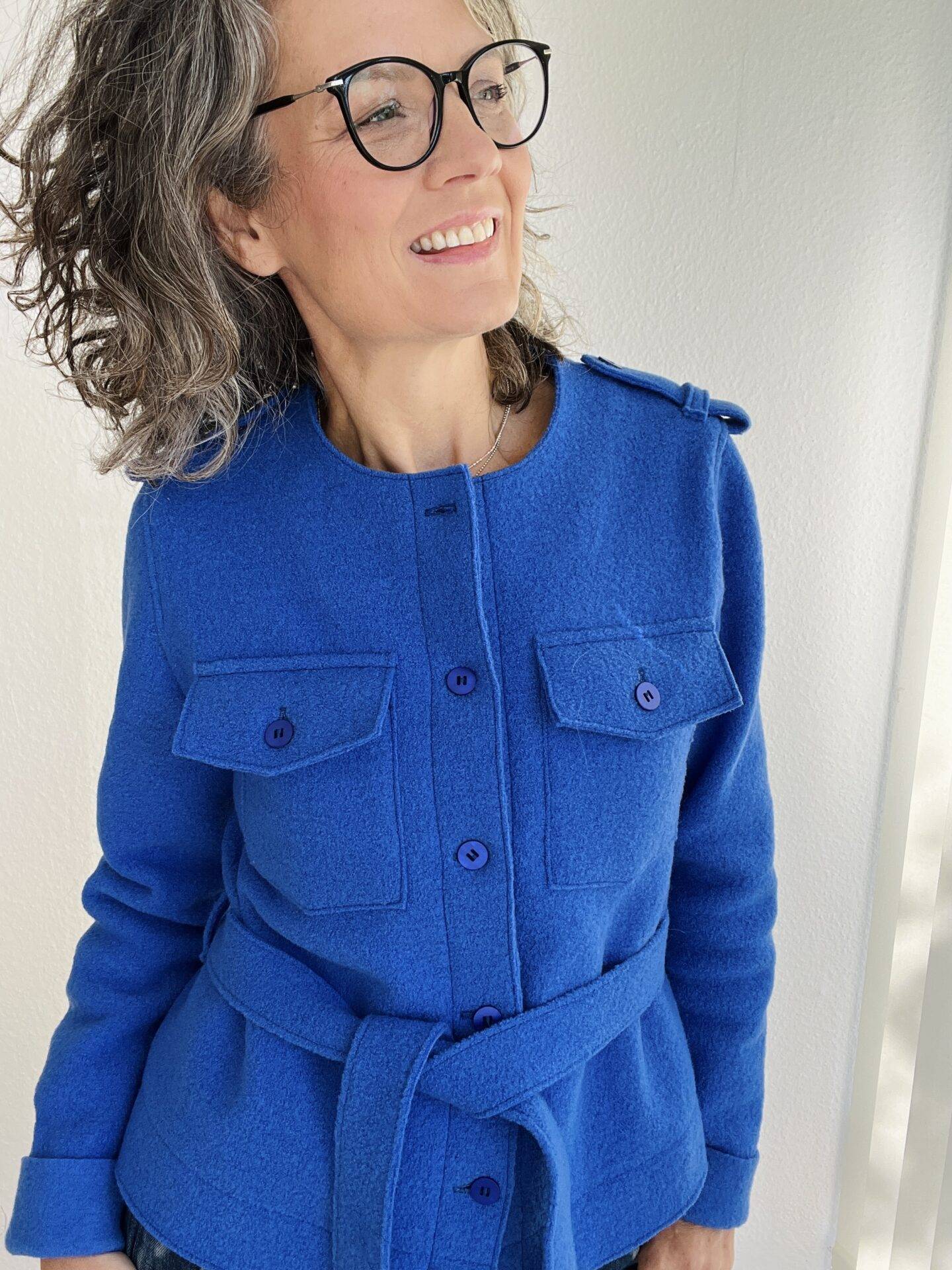 schnittmuster jacke eliza add on download Frau in blauer Jacke lächelt zufrieden.