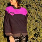 Frau mit Sonnenbrille vor grünem Zweig.