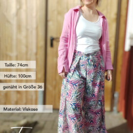 Frau in Sommerkleidung, rosa Hemd, gemusterter Rock.