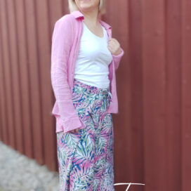 Person in Sommeroutfit vor Wand