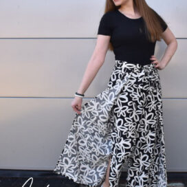 Lächelnde Frau in langem, gemustertem Rock.