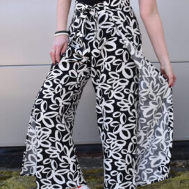 Frau mit floral gemusterten Hosen und Sneakers