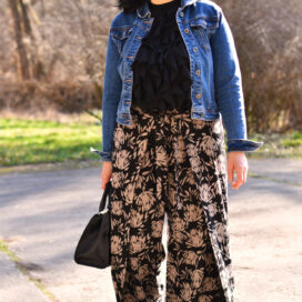 Person im Freien mit schwarzer Hose und Jeansjacke.