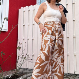 Frau in Sommeroutfit vor roter Hauswand