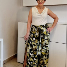 Frau in gemustertem Rock und weißem Top