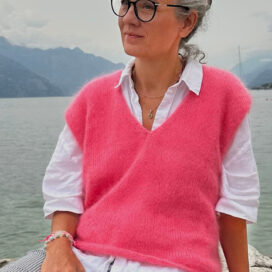 Frau in rosa Pullover am Wasser.