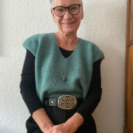 Lächelnde Frau trägt grünen Pullover