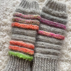 Warme, graue Armstulpen mit bunten Streifen.